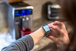 Human Hand Using an application on smart watch. The app is being used to control coffee machine inside a smart home.